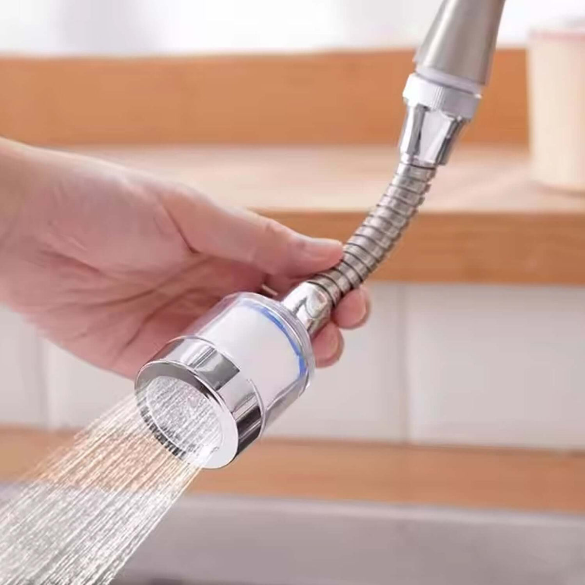 Water-saving faucet extender with flexible neck demonstrating water flow in kitchen sink setting.