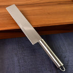 Ultra-sharp vegetable cleaver knife placed on a wooden cutting board, showcasing its wide, heavy blade.