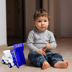 Child playing with a friction powered dumper truck for kids, engaging with the toy on the floor.