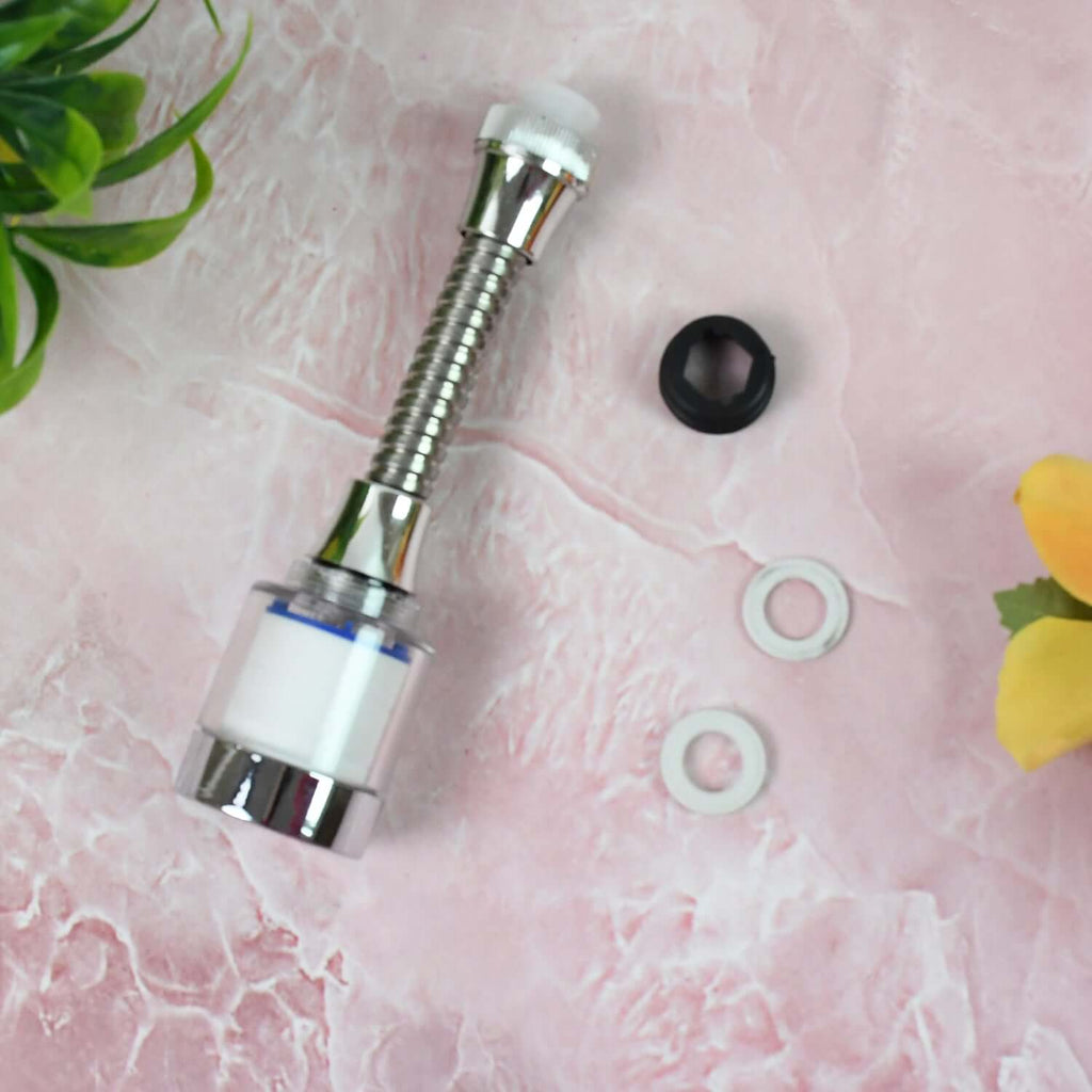 Water-saving faucet extender with 360 degree flexible neck and accessories on pink surface.