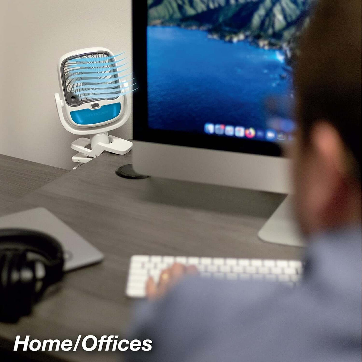 Portable clip fan with LED light mounted on desk next to computer, providing cool air for home or office use.
