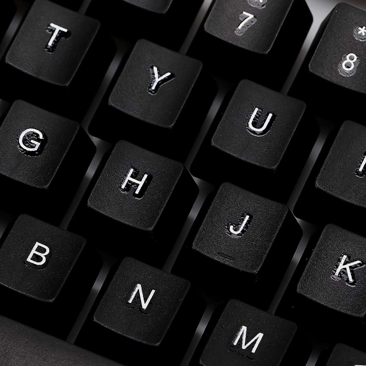 Close-up of black keys on a 104-key backlit gaming keyboard and mouse set, showcasing floating keycap design.