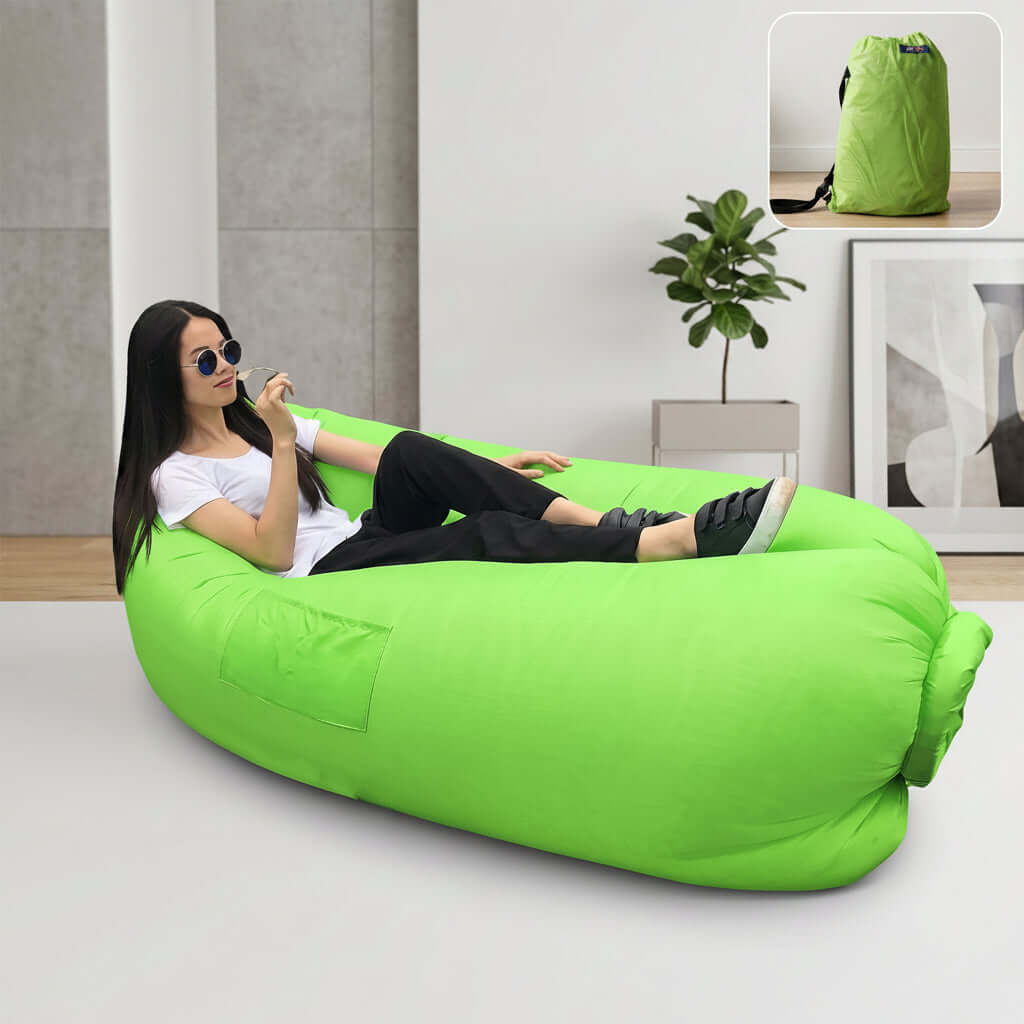 Person relaxing on an inflatable air lounger for outdoor use in a modern living room setting.