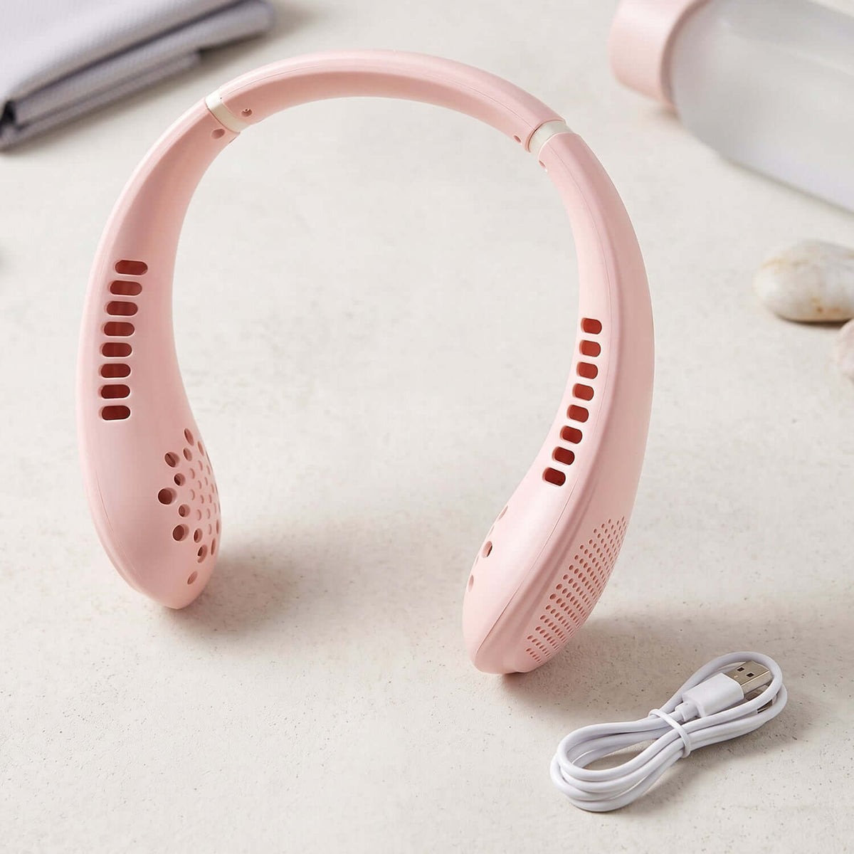 USB Rechargeable Bladeless Neck Fan in pink color with a USB charging cable, designed for hands-free cooling.