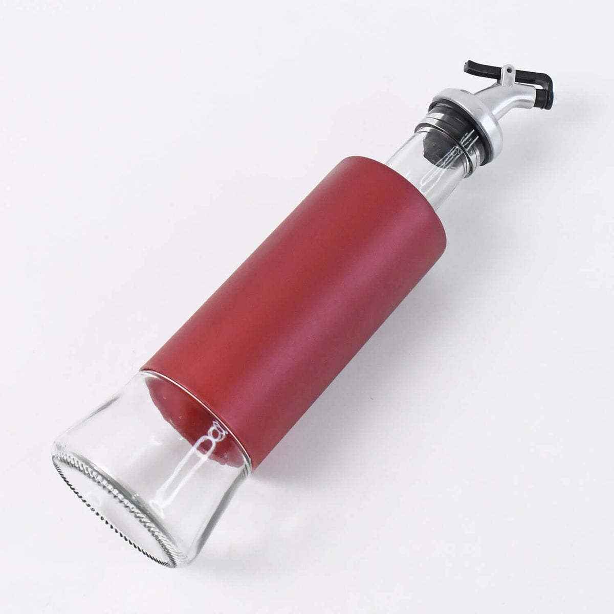 Glass oil vinegar dispenser bottle with red sleeve and pour spout for precise pouring.