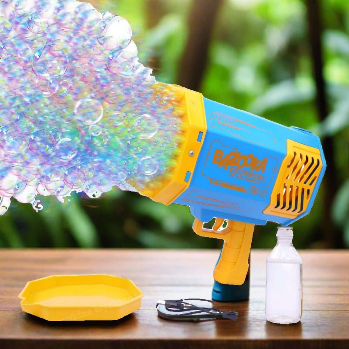 Rechargeable bubble gun for kids shooting vibrant bubbles, with a yellow tray and charging cable on a wooden table.