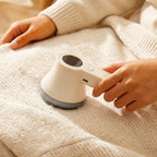 Rechargeable Lint Remover for Clothes being used on a knitted garment to remove lint and fuzz.