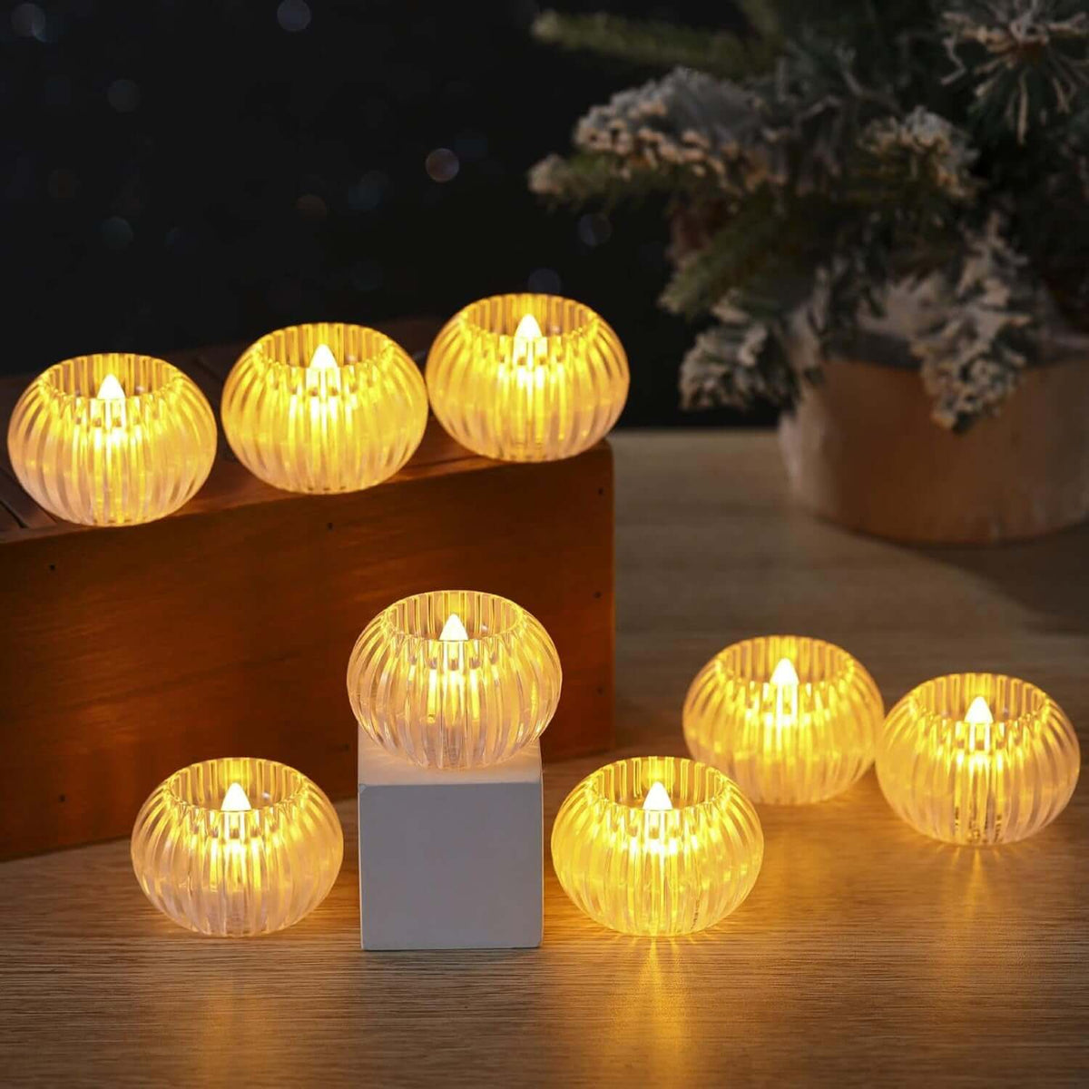 Set of 12 LED flameless tealight candles on a wooden surface, flickering gently in a cozy setting.