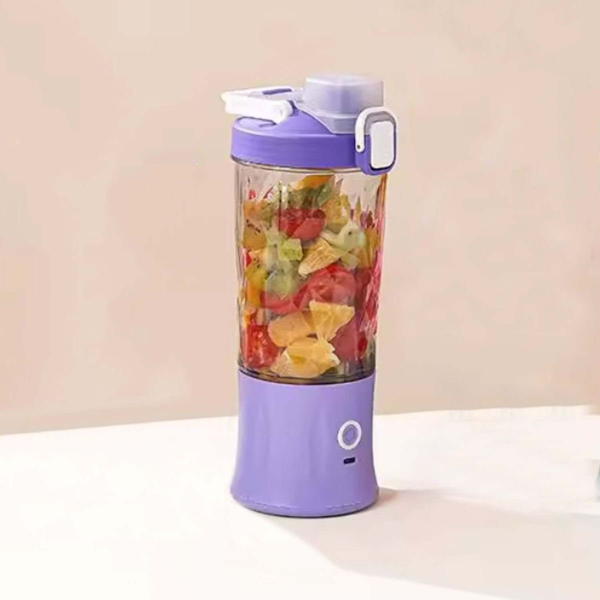 Portable electric juicer blender filled with colorful fruits on a table, showcasing its sleek design and functionality.