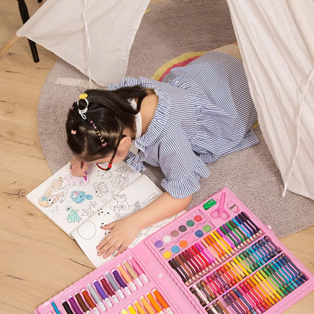 Girl drawing with 86-Piece Kids Art Set with Colouring Case on the floor, surrounded by art supplies.