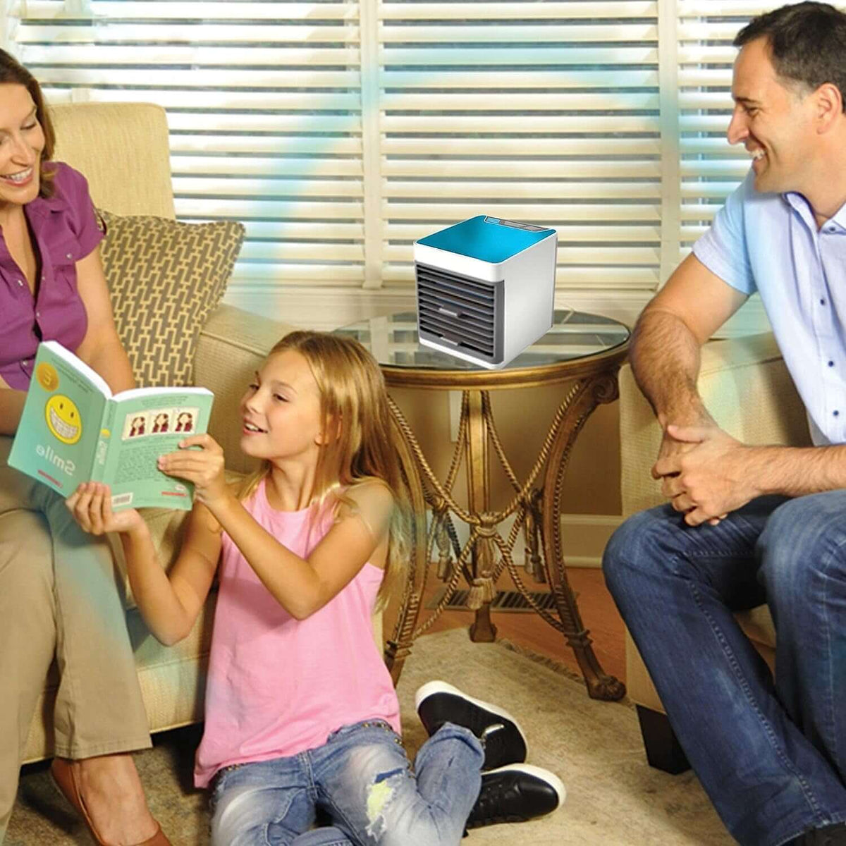 Mini portable air cooler with LED light on a table beside a family enjoying a book together.
