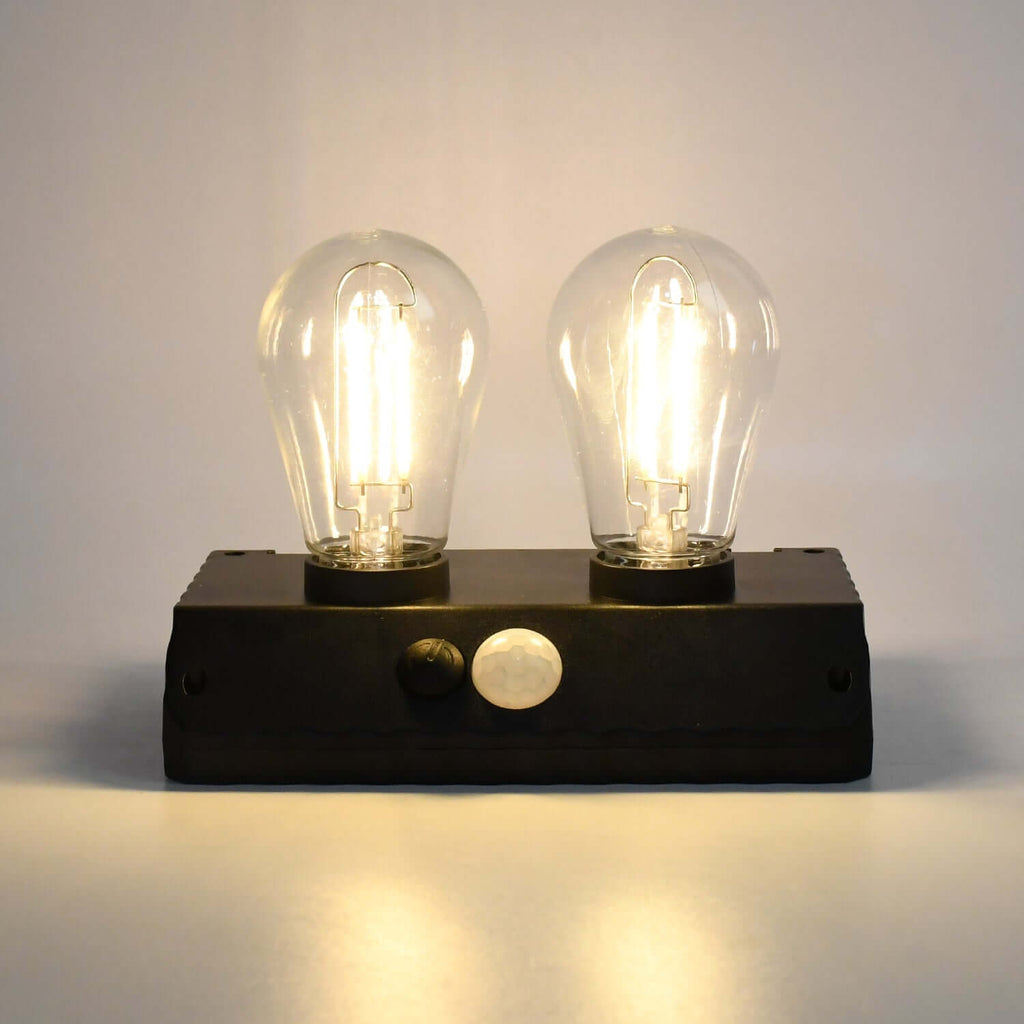 Solar powered LED wall lamp featuring two illuminated bulbs, ideal for outdoor lighting.