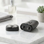 Portable cordless electric shaver for men on a marble countertop next to a small plant.